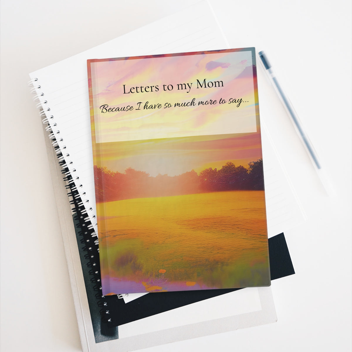 Letters to My Mom remembrance journal displayed with stationery showing its sunset cover and heartfelt memorial message